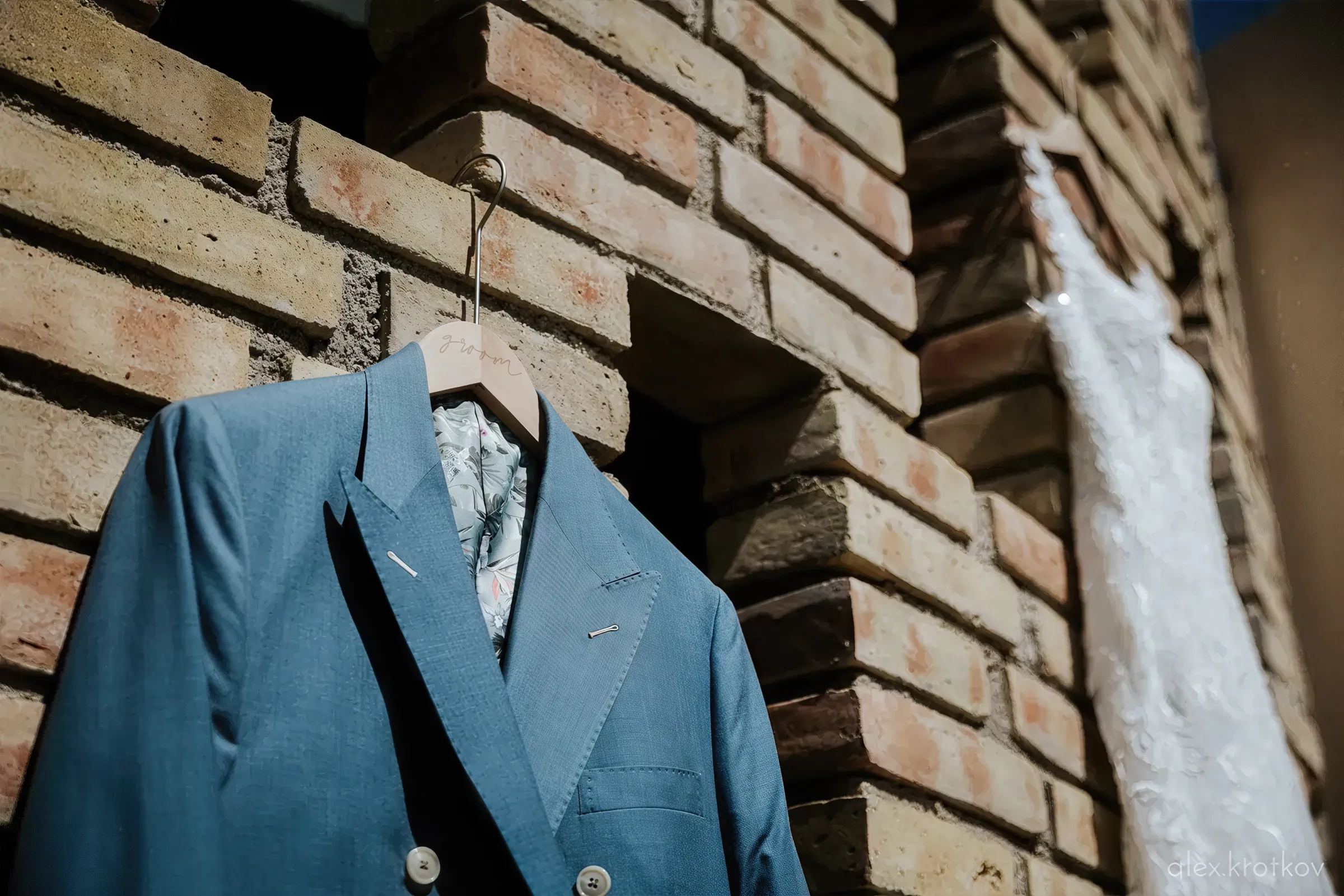 Suits and weeding dress on a brick wall